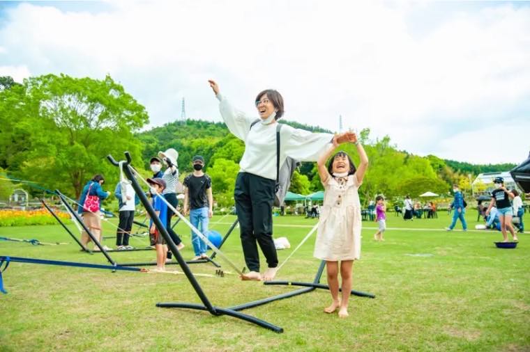 スラックラインの上をはだしで歩く親子