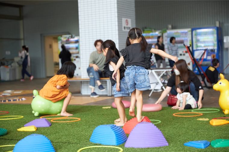 バランス遊具を並べた会場で遊ぶ子どもたち